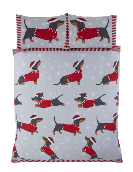Close-up of the novelty duvet design with a sausage dog in festive winter attire on a grey background with snowflakes