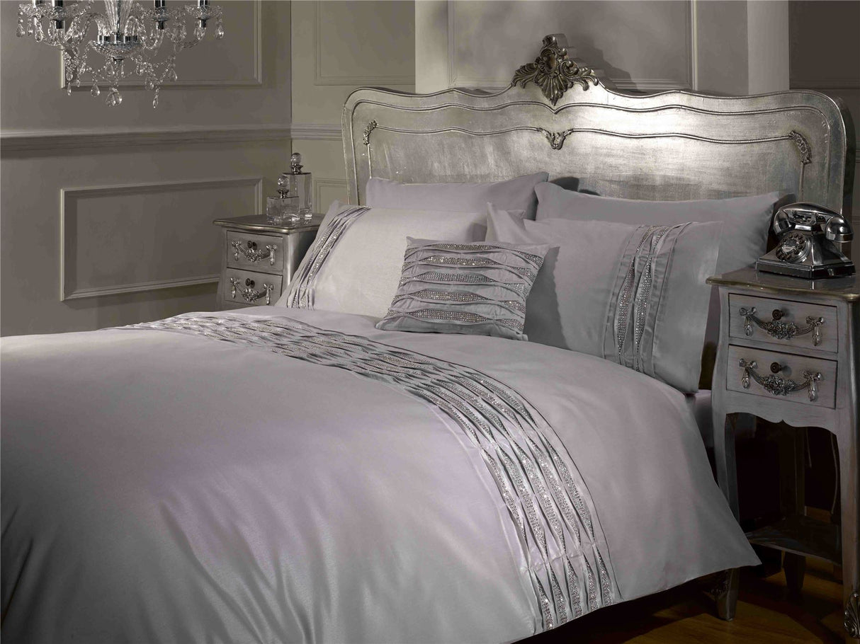 Elegant bedroom display showcasing the Crystal Duvet Set with its shimmering silver faux silk surface and luxurious diamanté embellishments