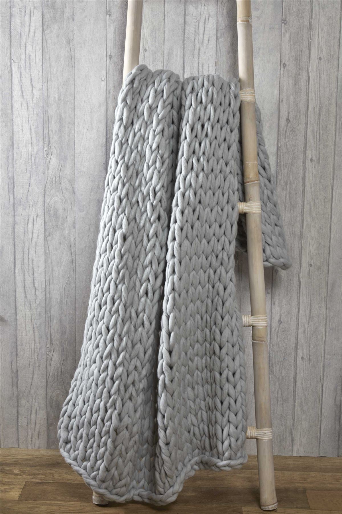 Elegant bedroom setting featuring a cable knit throw folded neatly at the foot of the bed, adding style and comfort