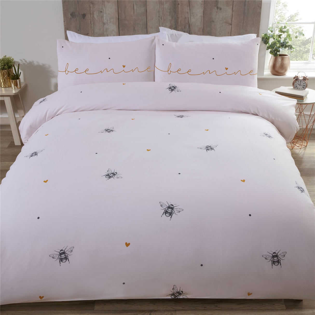 A pretty bee mine duvet cover featuring scattered bumblebees and love hearts on a pale blush pink background with matching pillowcases