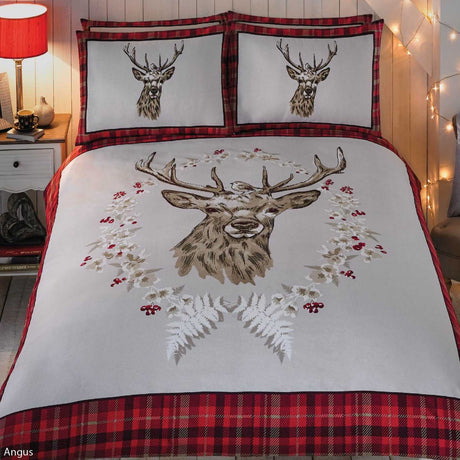 Close-up of the Angus Stag Brushed Cotton Duvet Set featuring a striking stag head design amid festive winter garland and a robin sitting on the stag's head
