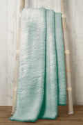 Stylish teddy throw casually placed on a sofa, highlighting its cosy and decorative appeal