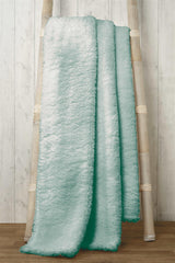 Stylish teddy throw casually placed on a sofa, highlighting its cosy and decorative appeal