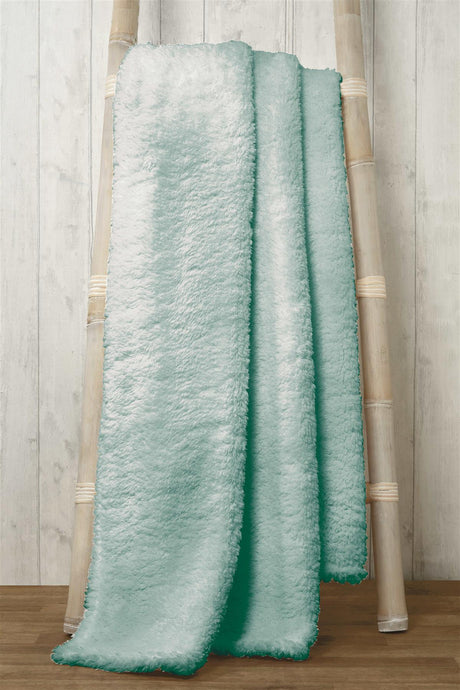 Stylish teddy throw casually placed on a sofa, highlighting its cosy and decorative appeal