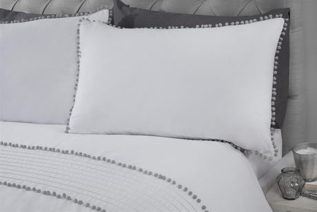 Minimalistic white duvet cover adorned with grey pom pom bobble trim along the edges