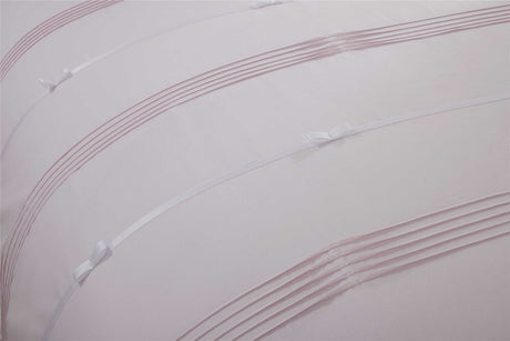 Opulent Clarissa duvet set with intricate pintuck design and delicate contrasting ribbon bows