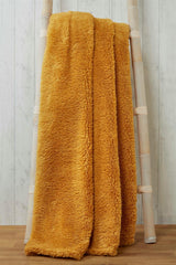 Close-up of soft, fluffy teddy throw with detailed stitching and textured fabric for ultimate comfort