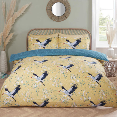 Close-up of the Cranes Duvet Set showcasing the delicate cranes in flight on an ochre backdrop, featuring a reversible lace pattern in teal for versatile styling
