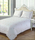 Intricately embroidered rose patterns on cream duvet cover with lace trim