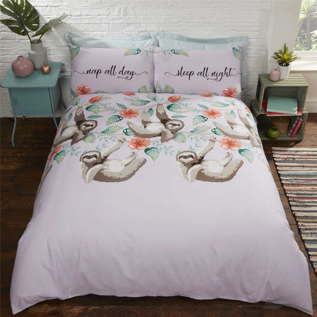 A detailed image of a Sloths Duvet Set featuring adorable illustrated sloths on a lilac background with floral accents and quirky slogan pillowcases, showcasing different sizes including single, double, and king with matching pillowcases, all made from easycare fabric with popper closures