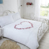 Matching pillowcases with embroidered hearts, pintucks, and detailed motifs for a cohesive bedroom look