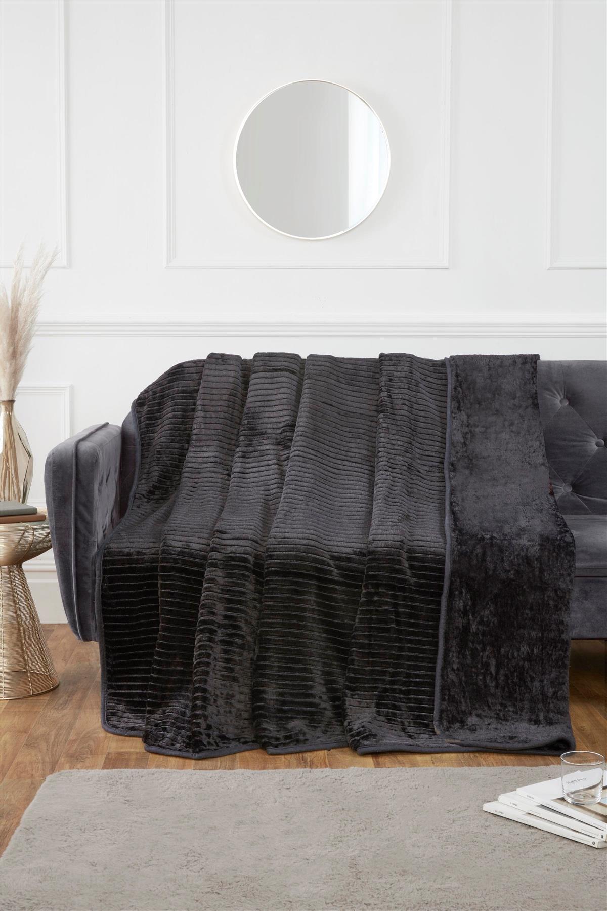Vibrant coloured mink blanket styled on a contemporary sofa for an inviting atmosphere