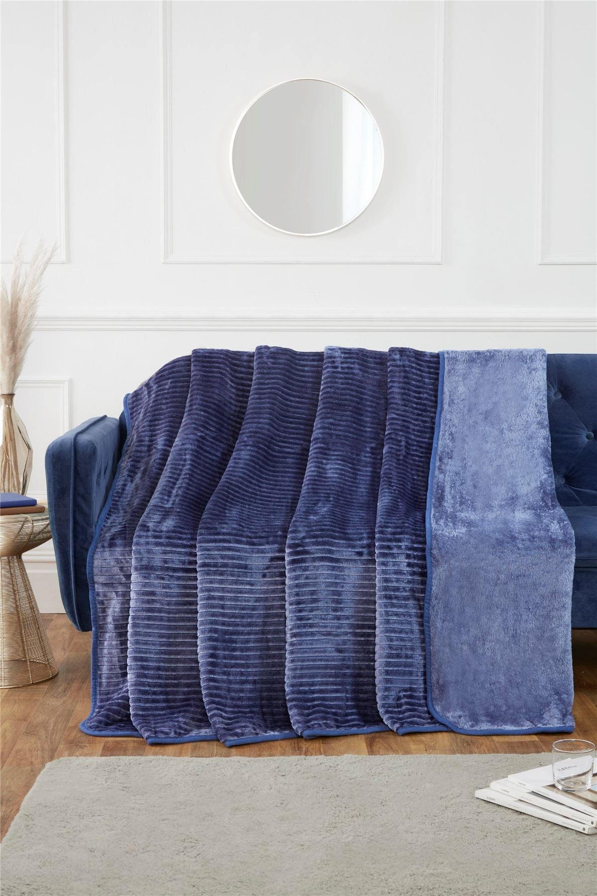 Luxurious ribbed faux fur blanket in vibrant colour draped over a modern sofa