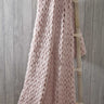 Luxurious cable knit chunky throw draped over a cosy armchair in a stylish living room