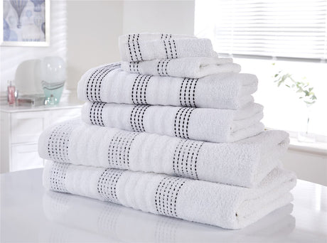 Arranged set of all towels including face cloths, hand towels, and bath towels on a clean bathroom surface