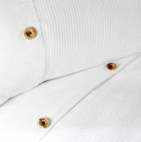 Detailed shot of waffle-patterned bedding set showcasing the simple yet beautiful horizontal border with button embellishments