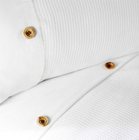 Detailed shot of waffle-patterned bedding set showcasing the simple yet beautiful horizontal border with button embellishments