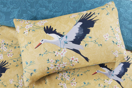 Elegant cranes in flight on an ochre background with a fully reversible printed lace pattern in teal, designed to add colour and quirkiness to the bedroom decor 