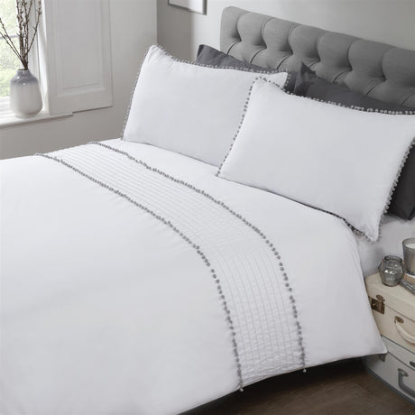 Close-up of the white duvet cover featuring contrasting grey pom pom trim and delicate bobble detailing