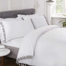 Elegant white bedding with contrasting grey tassel trim around duvet cover and matching pillowcases for a stylish bedroom look