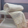 A cosy bed featuring the Stitch Stripe Throw with its colourful striped design and tasselled trim