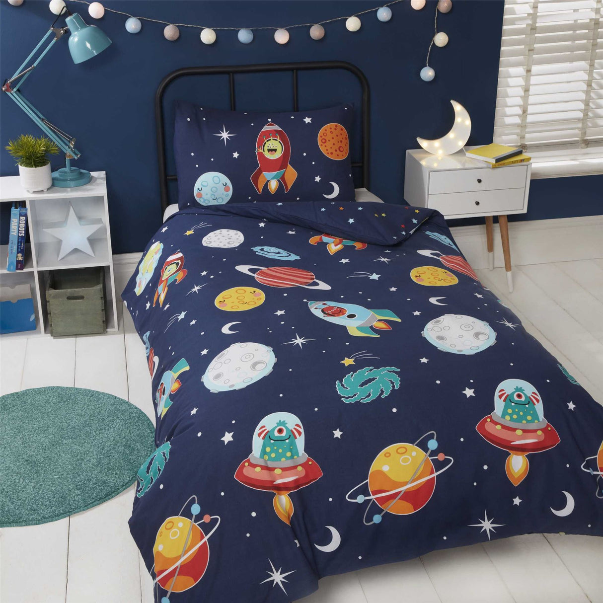 A vibrant space and aliens duvet cover featuring planets, stars, and aliens on a dark blue background illuminated in glow in the dark