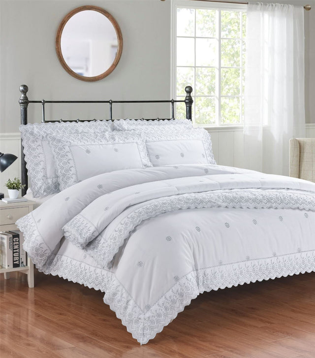 A beautifully crafted Gabrielle Bedspread featuring intricate floral embroidery and delicate lace trim, adding timeless elegance and sophisticated charm to a serene bedroom setting