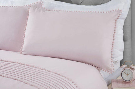 A styled bedroom scene showcasing the Pom Poms Duvet Set with grey bobble trim on the pillowcases and duvet cover
